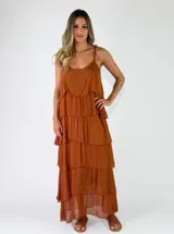 Vestido largo tipo solera de color terracota, con tirantes finos y diseño en capas escalonadas.