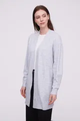 Saco abierto de punto, color gris claro, con diseño holgado y mangas largas.