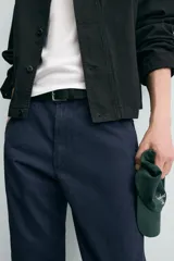 Pantalón de corte carrot fit confeccionado en tejido de algodón con estructura diagonal y efecto lavado. Presenta bolsillos frontales con bolsillo cerillero, bolsillos traseros de plastrón y cierre frontal con cremallera y botón.