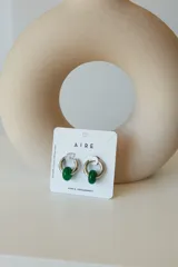 Aros de argolla en acero quirúrgico con dije de piedra natural en tono azul.