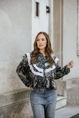 Camisa de lino con estampado abstracto en tonos oscuros, presenta volados decorativos con puntilla blanca en el frente y hombros, cuello clásico y mangas largas.