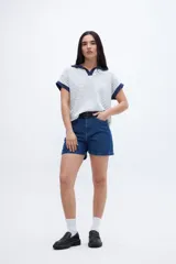 Remera con cuello tipo polo y escote en V, a rayas horizontales color beige y blanco, con cuello y mangas color beige liso.