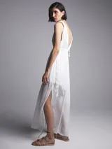 Mono largo blanco con escote en V, breteles finos con lazo y tajo lateral en la pierna.