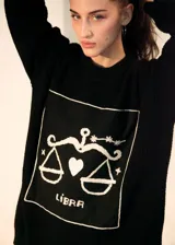 Sweater de punto oversize color crudo, con cuello redondo y diseño bordado a mano en el frente representando al signo Cáncer con un cangrejo, un corazón y una estrella.