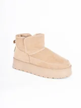 Bota corta tipo ugg con plataforma dentada, confeccionada en material gamuzado color beige con interior forrado en piel sintética.