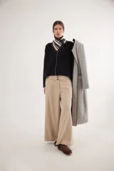 Pantalón de jean con diseño de tiro medio-bajo y piernas anchas. Presenta una pretina ancha con cierre de tres botones metálicos frontales, pinzas decorativas en la cintura y bolsillos delanteros funcionales.