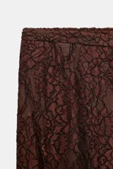 Pantalón bombacho de tiro alto con cintura elástica y puños ajustados, confeccionado en encaje color crudo con forro interior corto a tono.