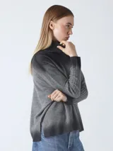 Suéter de tejido de punto con efecto degradado, pasando de gris oscuro a gris medio. Presenta cuello alto y mangas largas con puños acanalados.