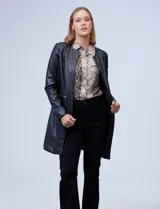 Chaqueta larga de eco cuero color negro, con cuello a la base, abertura central y bolsillos delanteros.