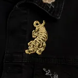 Pin dorado con forma de tigre.