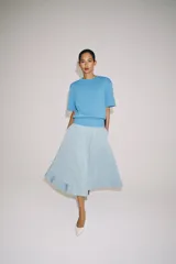 Falda midi de tiro alto en color negro, con diseño en línea evasé y cierre de cremallera oculta en la costura.