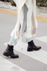 Bota tipo chelsea de cuero color marrón oscuro, con paneles laterales elásticos y suela track robusta con plataforma.