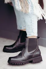 Bota tipo chelsea de cuero color marrón oscuro, con paneles laterales elásticos y suela track robusta con plataforma.