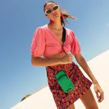 Bolso porta celular con cierre frontal, compartimentos internos para tarjetas y bolsillo trasero. Incluye correa elástica regulable y desmontable.