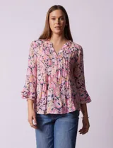 Blusa estampada con flores en tonos rosa, naranja y azul marino. Tiene escote en V con detalle de pliegues y mangas 3/4 con volados.