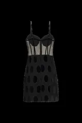 Vestido corto negro sin mangas confeccionado en terciopelo y tul transparente, con corsé estructurado con ballenas y tirantes finos. Presenta detalles de pedrería y bordados brillantes en las copas, los tirantes, las costuras frontales y a lo largo de la falda de encaje.