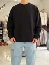 Buzo oversize de corte amplio, color blanco, con cuello redondo y puños y dobladillo en rib elástico.