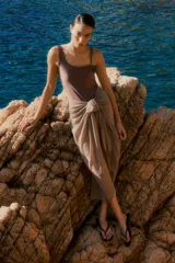 Pareo de tela ligera con diseño envolvente y nudo frontal, ideal para usar sobre trajes de baño.