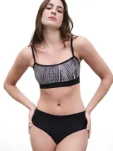 Top deportivo negro con estampado de rayas verticales blancas y tirantes finos.
