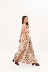 Vestido largo de tela sedosa con estampado abstracto en tonos camel, blanco y negro, escote en V pronunciado, tirantes anchos y tajos laterales.