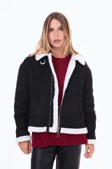 Campera de estilo aviador en color negro, confeccionada en material tipo gamuza con interior y bordes de corderito blanco. Presenta cierre frontal, cuello con solapas y hebilla metálica decorativa.