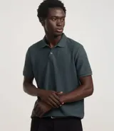 Camisa polo de corte regular, color verde oscuro, confeccionada en tejido texturizado. Presenta cuello clásico con botones frontales y mangas cortas.