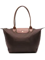 Bolso tote plegable de nylon color marrón oscuro, con asas y solapa de cuero color camel. Presenta un diseño clásico con cierre superior y un caballo al galope grabado en la solapa.