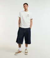 Remera blanca de algodón, corte comfort, con cuello redondo y mangas cortas. Estampa en la espalda con una garza, texto en japonés y la frase "flow like the wind".