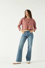 Remera de manga larga y corte boxy color marrón rosado, con cuello redondo y estampa frontal con la leyenda "HER TRUE".