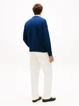Sweater azul de punto grueso con cuello redondo, hombros caídos y logo bordado en fuente script en el pecho.