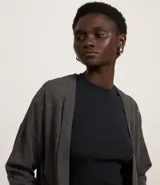 Cardigan de punto básico, con mangas largas y sisa desplazada. Presenta un diseño abierto sin botones, confeccionado en un tejido de punto ligero y versátil.