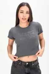 Remera crop gris oscura con estampa tipográfica al frente y mangas cortas.