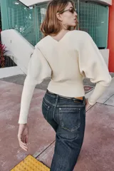 Jersey de punto color verde lima, con cuello pico y manga larga de sisa ancha que se estrecha hacia la muñeca.