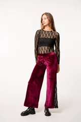 Pantalón de terciopelo color borgoña, corte recto y detalle de encaje negro en los laterales.