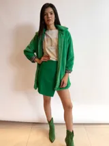 Minifalda verde de simil cuero con corte irregular.