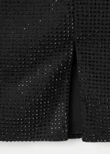 Minifalda negra de corte recto con acabado brillante y abertura lateral en el bajo. Cuenta con cierre de cremallera lateral y forro interior.