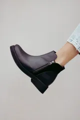 Bota corta de cuero negro con diseño minimalista, cierre lateral metálico y taco bajo cuadrado de 4 cm.