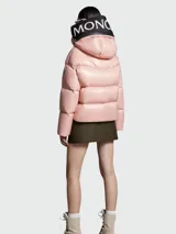 Campera puffer rosada con capucha integrada, cierre frontal con cremallera y bolsillos laterales con cierre.