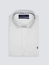 Camisa blanca de manga larga con cuello abotonado y cierre frontal de botones, con detalle de bordado en el pecho.