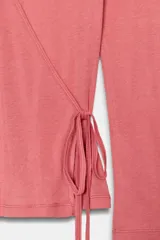 Camiseta de algodón Supima con diseño cruzado, escote en pico y cierre frontal ajustable mediante lazadas laterales. Presenta corte ajustado y manga larga.