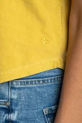 Remera oversize de algodón lavado color mostaza, de manga corta y cuello redondo. Presenta un pequeño bordado en forma de estrella en la parte inferior.