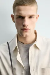 Camisa de corte relajado confeccionada en tejido de algodón con estampado de cuadros difuminados. Presenta cuello solapa, manga larga con puños abotonados, bolsillo de plastrón en el pecho y cierre frontal de botones.