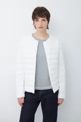 Campera acolchada tipo puffer en color beige, con diseño sin cuello y cierre frontal con botones a presión.