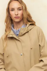 Pilot negro de manga larga con capucha, bolsillos de solapa y botones metálicos.