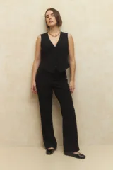Conjunto sastrero negro compuesto por un chaleco con escote en V y pantalón de vestir de corte recto y tiro alto.