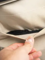 Mochila negra de poliéster con cierre superior enrollable, asa de mano y tirantes ajustables.