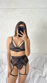 Conjunto de lencería compuesto por un bralette de encaje con tiras decorativas y una bombacha tipo portaligas con detalles en encaje y microtul.