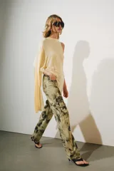 Top asimétrico de mezcla de lyocell en color amarillo claro, con cuello redondo y diseño fluido de corte irregular con una manga larga y un lateral drapeado.