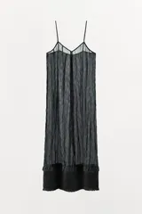 Vestido midi negro confeccionado en mezcla de viscosa con tejido satinado y efecto arrugado. Presenta escote en pico, tirantes finos ajustables, bajo con aplicación a tono y acabados deshilachados.