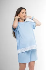 Pijama maternal de algodón gris con textura acanalada, compuesto por una remera de manga corta con broches laterales para facilitar la lactancia y detalle de puntilla blanca en el ruedo, y un short a juego con cintura ajustable.